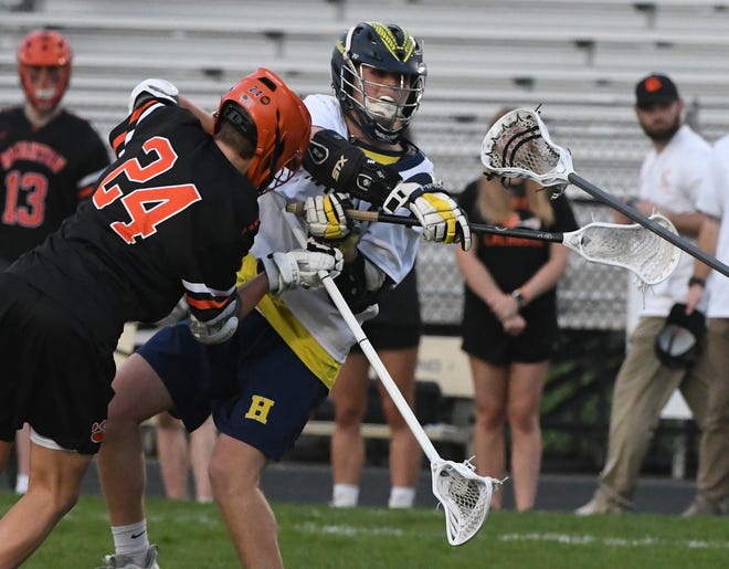 Brighton's Enzo Lange puts a hit on Hartland's Gavin Preston as he puts a shot on goal in the third quarter.