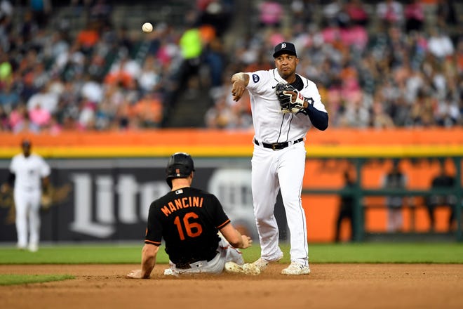 Tigers second baseman Jonathan Schoop throws to first base to complete a double play as Baltimore Orioles' Trey Mancini slides into second base during the sixth inning.