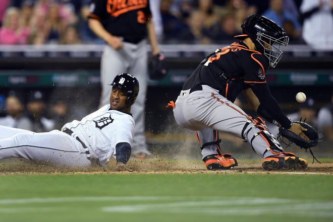 Tigers' Jonathan Schoop, left, scores on a double by Willi Castro as Baltimore Orioles catcher Robinson Chirinos loses control of the ball during the sixth inning.