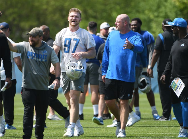 Lions rookie defensive lineman Aidan Hutchinson walks off the field with defensive line coach Todd Wash after minicamp.