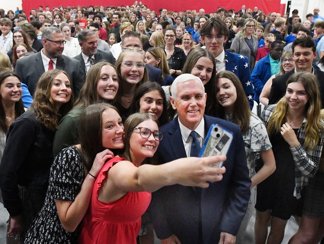 Former Vice President Mike Pence poses for selfies with  senior Lauren Kolodsick, 18, and other students at Lutheran Northwest, after an assembly on "Let Michigan kids learn Initiative" about a school of choice tax credit initiative in Rochester Hills, Michigan on May 17, 2022.