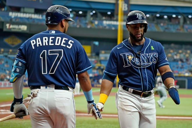 Tampa Bay Rays' Yandy Diaz, right, shakes hands with on-deck batter Isaac Parades after scoring on a bases-loaded walk by Detroit Tigers starting pitcher Eduardo Rodriguez during the first inning.
