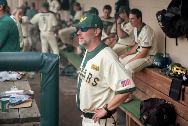 Wayne State head baseball coach Ryan Kelley watches the game from the dugout.