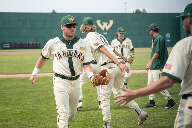 Wayne State infielder Chris Tanderys, left, gets high-fives from his teammates during Thursday's game.