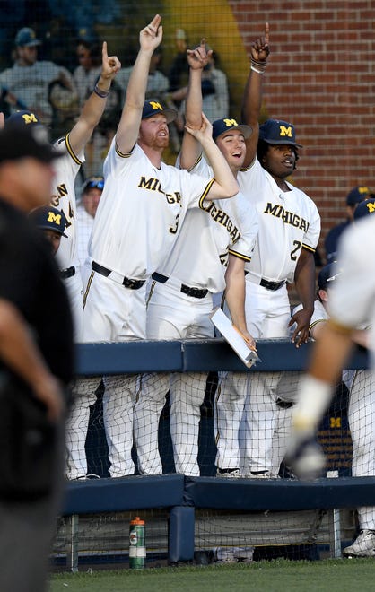 Michigan's dugout cheers on the team in the seventh inning.