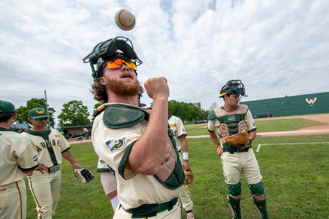 Wayne State catcher Ryne Travis, left, and his teammates warm up before Thursday's NCAA Division II Midwest Regional game against Walsh.