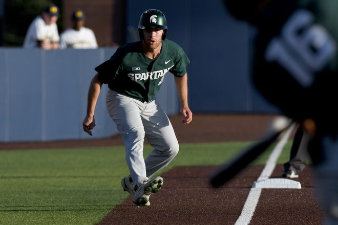 Michigan State base runner Jack Frank sneaks down the third base line as he gets ready to score on a single in a losing effort against Michigan.