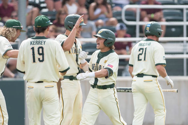 Wayne State's Noah Miller, center, is congratulated by his teammates after tripling and scoring on an error in the third inning.
