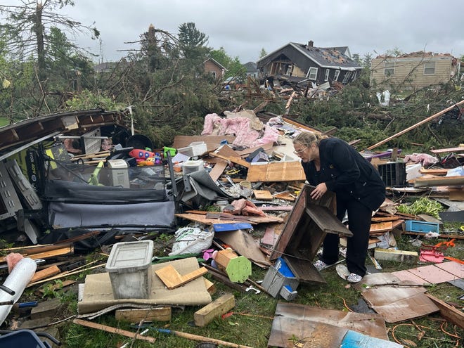 Theresa Haske sorts through debris from what was her garage after a tornado tore through Gaylord, Mich., on Friday, May 20, 2022.