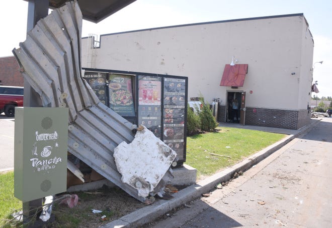 A tornado Friday, May 20, 2022, in Gaylord, Mich., wrapped roofing material around the Panera Bread drive-thru menu sign.