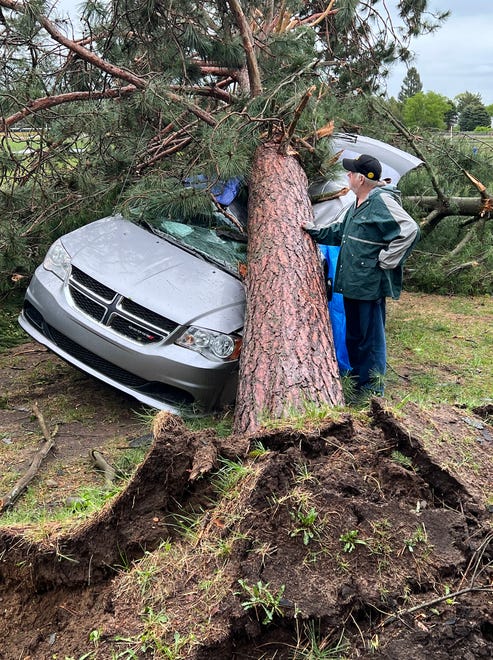 Jack Elliott inspects his 2017 Dodge Friday, May 
20, 2022, after a red pine crushed the vehicle in a tornado in Gaylord, Michigan.