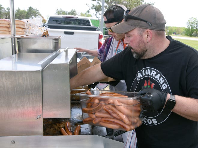 John Richardson of Nowicki's Sausage Shoppe prepares hot dogs Saturday for support crews and personnel at the staging area in Gaylord, Saturday, May 21, 2022. His crew will dispense 1,000 hot dogs for the volunteers and rescue personnel.