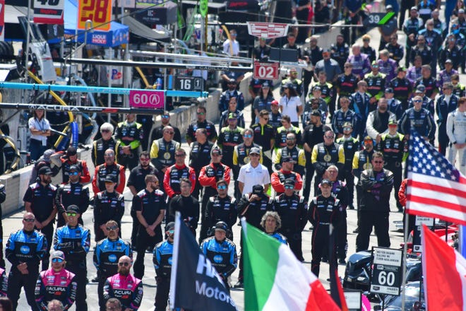 Racing crews stand in pit lane for the start of the  IMSA Weather Tech Sports Car Championship during the 2022 Chevrolet Detroit Grand Prix on Saturday, June 4, 2022.