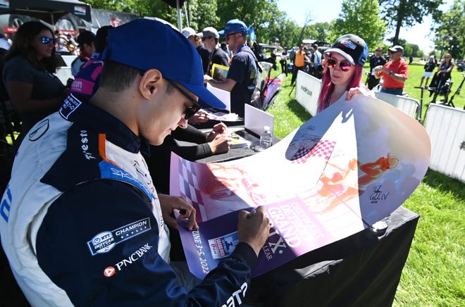 Indy driver Alex Paldu (left) signs an autograph for race fan Katie Fuller during the 2022 Chevrolet Detroit Grand Prix on Saturday, June 4, 2022.