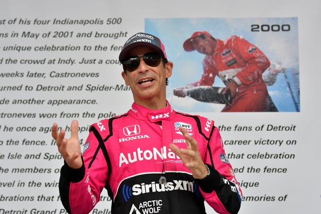 IndyCar driver Helio Castroneves speaks, reunited with his 2000 winning car, at the Grand Prix legacy tent.