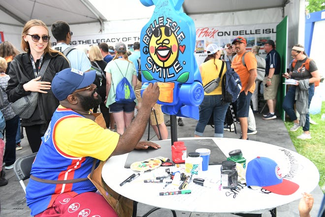 Artist Phillip Simpson paints a replica IndyCar for promotion at the Grand Prix legacy tent in the Fan Zone at the Chevrolet Detroit Grand Prix on Belle Isle in Detroit on June 5, 2022.   Other replicas will be painted by Detroit students and eventually the replicas will be on display around the districts of the Detroit.