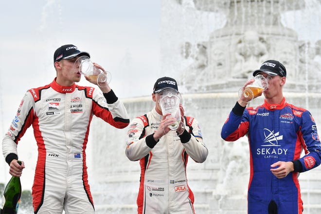 From left, Indy Lights drivers Hunter McElrea, Linus Lundqvist and Sting Ray Robb drink from their trophies after their race at the Chevrolet Detroit Grand Prix on Belle Isle in Detroit on June 5, 2022.   
(Robin Buckson / The Detroit News)