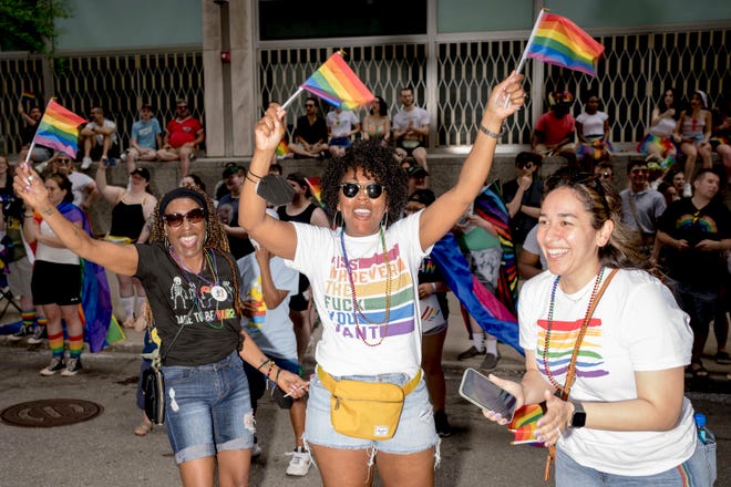 From left, Pat Smith of Ecorse, Andrea Moss of Grand Rapids and Angelica Taylor of Ypsilanti cheer during the Motor City Pride parade in Detroit.