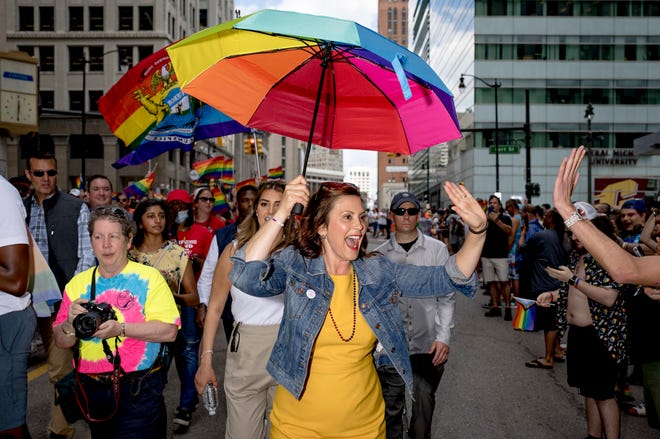 Gov. Gretchen Whitmer gives out high-fives during the Motor City Pride parade in Detroit on June 12, 2022.