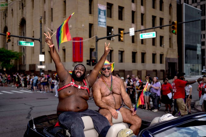 Logan Woodrow of Lansing, left, and Rob Pierce of Farmington Hills participate in the Motor City Pride parade in Detroit.