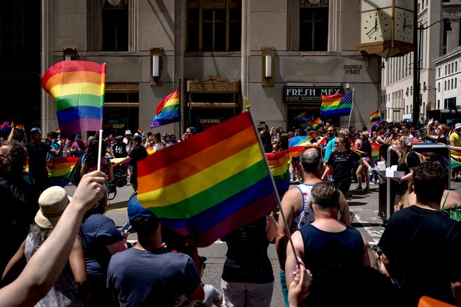 People wave flags during the Motor City Pride parade in Detroit.