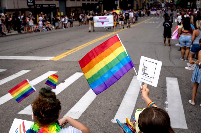 People raise flags during the Motor City Pride parade in Detroit.