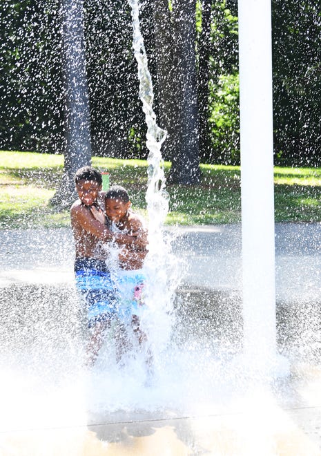 l-r, NaShawn Davis, 11,of Detroit and his brother Lammar Davis Jr., 9, enjoys the cold water at Palmer Park splash pad in Dettroit.