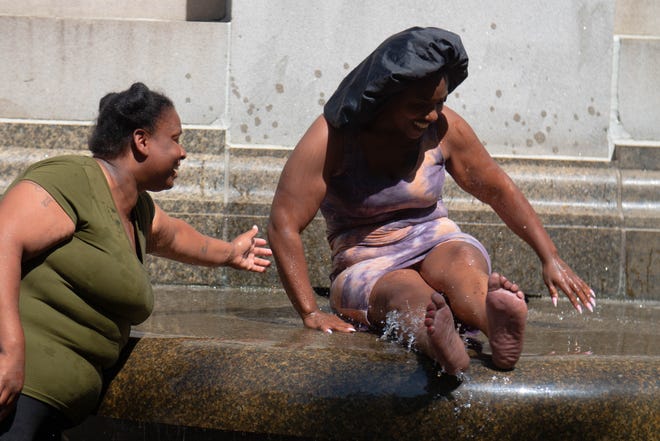 (Left to Right) Ebony Cody and Tammisha Givant cool off at the Michigan Soldiers and Sailors Monument in Detroit, Michigan on Wednesday June 15th, 2022.