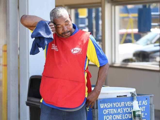 Willie Williams, 53, of Detroit, a 12-year employee at Jax Car Wash in Royal Oak, takes a break from the heat while wiping cars as they exit the car wash..