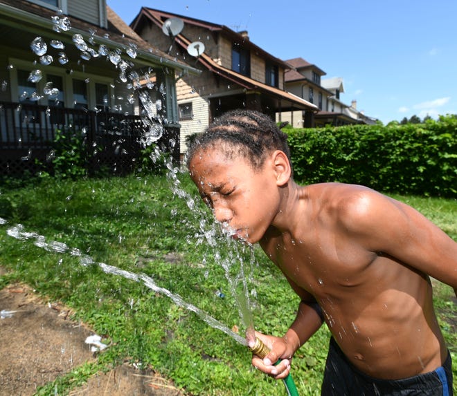 Zoeser Barnes, 9, of Highland Park, cools off while playing in the water hose during 95-degree-plus temperatures, Wednesday afternoon, June 15, 2022.