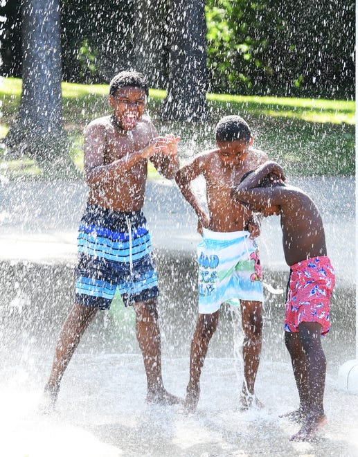 Brothers l-r, NaShawn Davis, 11,of Detroit, Lammar Davis Jr., and Marceil Davis,7, enjoys the Palmer Park Splash Pad in Detroit.