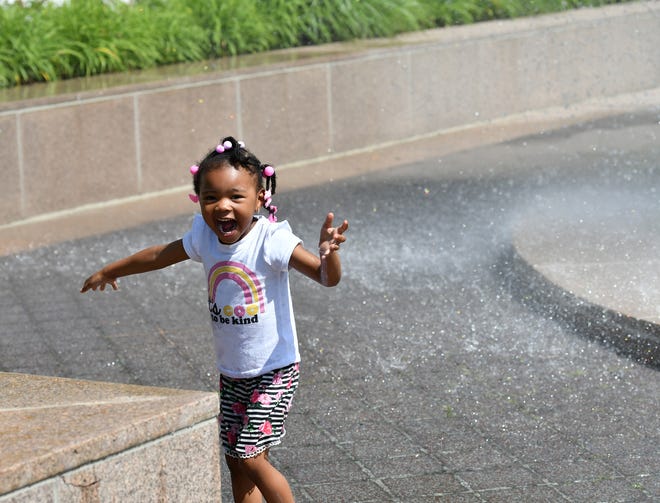 Legacy Clark, 3, reacts to the cool spray from one of the fountains in front of the Detroit Institute of Arts in Detroit on June 15, 2022.  She was there cooling off with her dad, Emerson Clark, 60, of Detroit.