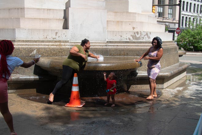 (Left to Right) Tashaire Givantt, Ebony Cody, Nevaeh Cody, and Tammisha Givant cool off at the Michigan Soldiers and Sailors Monument in Detroit, Michigan on Wednesday June 15th, 2022.