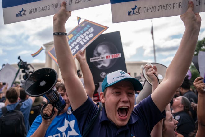 Anti-abortion activists react to the 6-3 ruling in Dobbs v. Jackson Women's Health Organization which overturns the landmark abortion Roe v. Wade case in front of the Supreme Court on June 24, 2022 in Washington, DC.