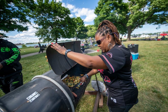 Andrea Hakeem, the secretary for the Pedal Up Bicycle Club, prepares food for the club's members before the start of the annual fireworks show, on Belle Isle, in Detroit, June 27, 2022.