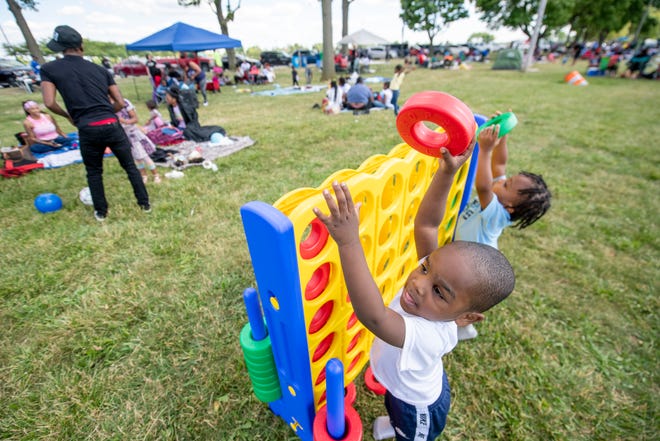 Three-year-olds Quartez Jones, left, and Ethan Johnson play together while waiting for the start of the annual fireworks show, on Belle Isle, in Detroit, June 27, 2022.