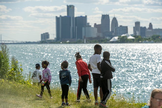 Kids play near the water while waiting for the start of the annual fireworks show, on Belle Isle, in Detroit, June 27, 2022.