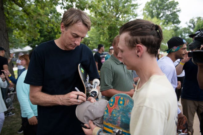 Legendary skateboarder Tony Hawk signs autographs for young skaters.