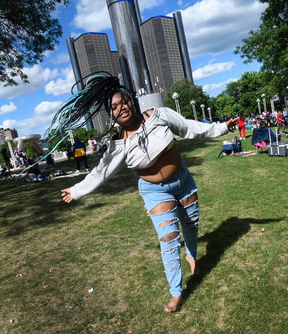 Arianna Jones, 17, has fun along the Detroit River waiting for the fireworks display in downtown Detroit.