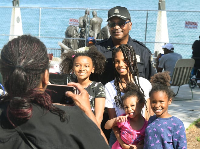 Leia Yawson Dickerson, 9, Janiyah Jarrett, 10, Amora Dickerson, 3, and Azaryah Jarrett get a picture with DPD Chief James E. White wondering through the crowd at Hart Plaza before the fireworks display.
