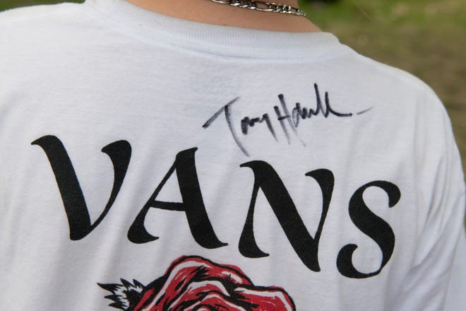The autograph of legendary skateboarder Tony Hawk is seen on the t-shirt of young skater Mason Farley.