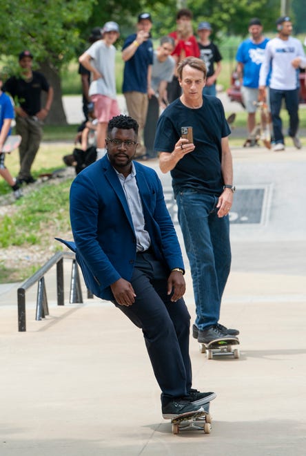 WDIV TV reporter Victor Williams rides a skateboard followed by legendary skateboarder Tony Hawk during the grand opening of the new Chandler Park Skatepark in Detroit.