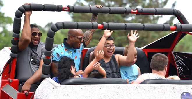 U.S. Army infantry veterans Terence Burse, left,  and Joe Montgomery, both of Detroit, laugh while riding in the bed of the Shell-Camino monster-ride truck, Saturday afternoon, July 2, 2022.