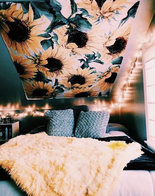 Tapestries can create a canopy on the ceiling like this sunflower pattern that adds a touch of nature to a small space.