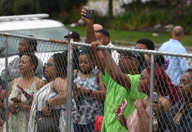 Motown fans peer through and over the fence during the event at the Motown Museum.