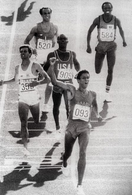Joaquim Cruz from Brazil raises his arm in victory after winning the 800m final in front of Sebastian Coe of Great Britain (L) and Earl Jones of the USA 06 August 1984 at the Olympic Games in Los Angeles.