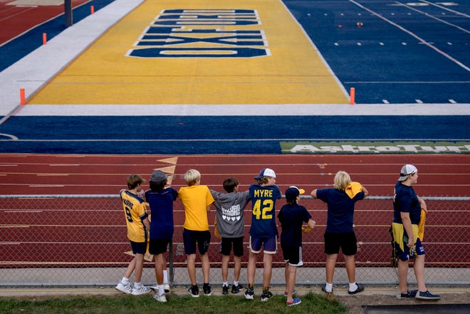Young fans wait for the high school football game between the Oxford Wildcats and Birmingham Groves Falcons to begin at Oxford High School in Oxford, Mich. on Sept. 2, 2022.