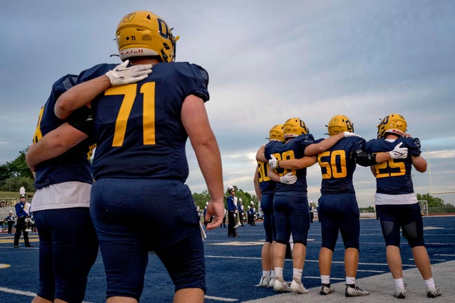 Oxford teammates embrace during a tribute video to Tate Myre during the high school football game between the Oxford Wildcats and Birmingham Groves Falcons at Oxford High School in Oxford, Mich. on Sept. 2, 2022.