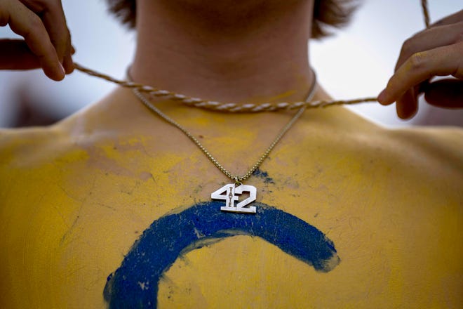 Senior Charlie Fracker, 16, wears a necklace in memory of Tate Myre before the high school football game between the Oxford Wildcats and Birmingham Groves Falcons at Oxford High School in Oxford, Mich. on Sept. 2, 2022.