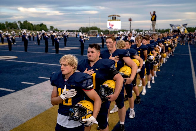 Oxford players look on during the national anthem of the high school football game between the Oxford Wildcats and Birmingham Groves Falcons at Oxford High School in Oxford, Mich. on Sept. 2, 2022.